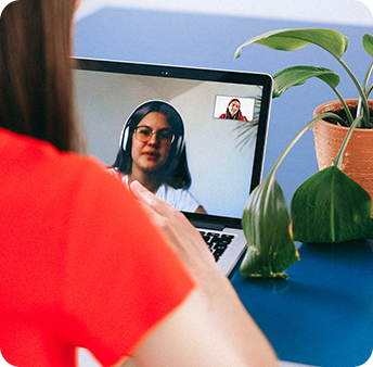 A person attending a video call on a laptop with another individual visible on the screen.